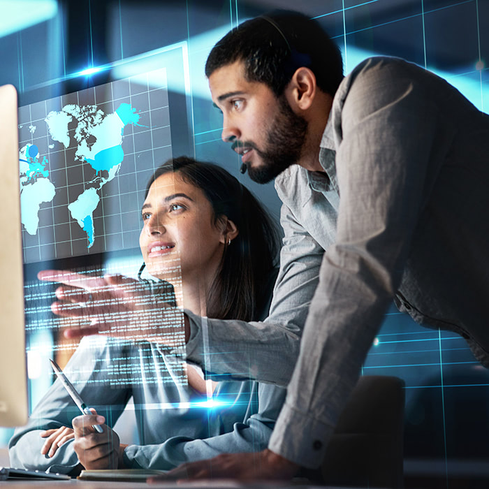 man and woman pointing at maps on computer